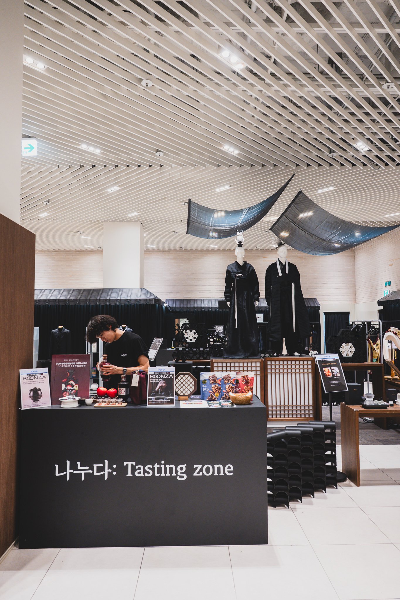 BOONZA tasting zone with two hanbok-dressed mannequins under a roof-shaped display structure