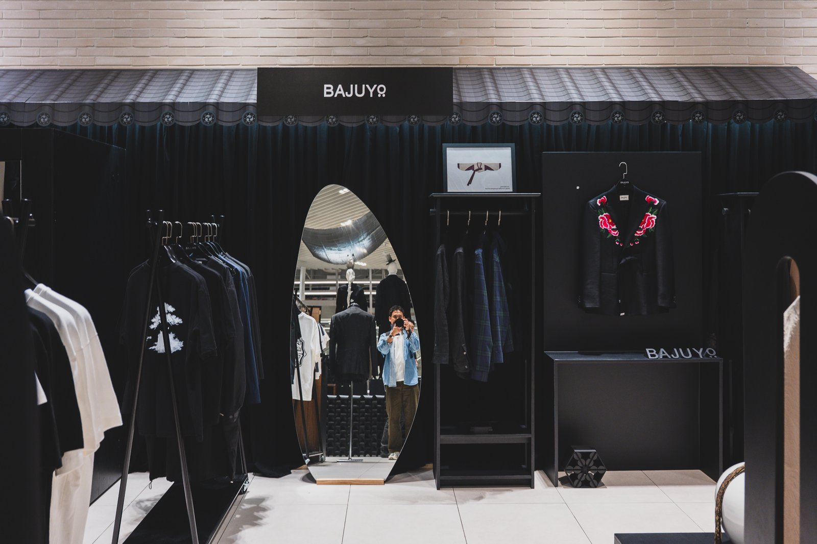 BAJUYO storefront with a roof-tile-shaped awning over racks of clothing