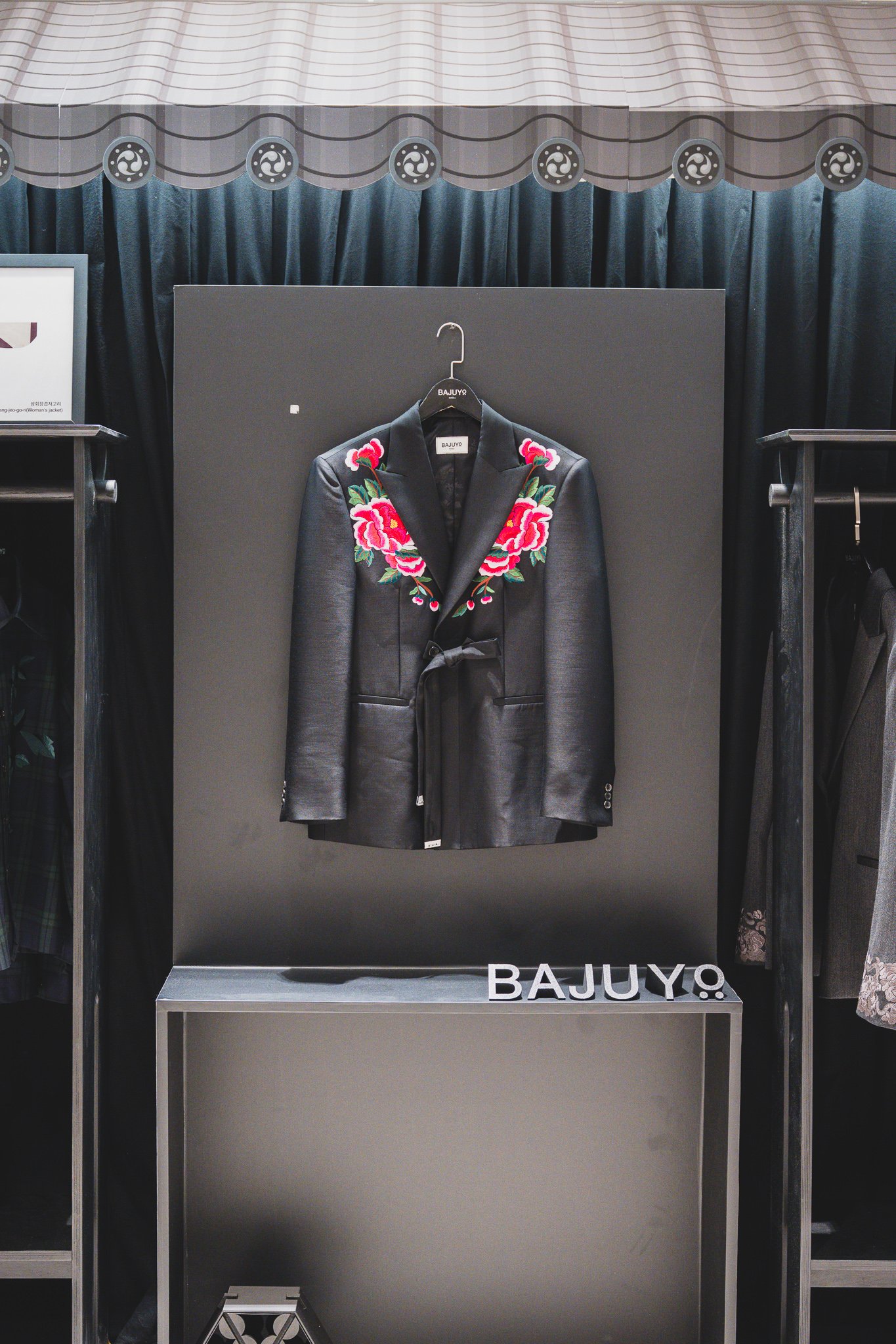 Black jacket with peony embroidery at the shoulder and collar, with a goreum-style ribbon tied at the waist
