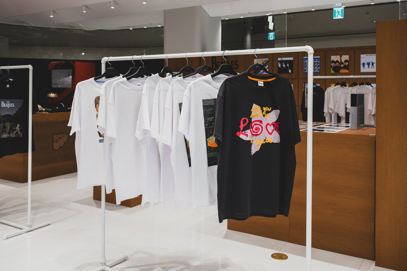 Rack of white and black t-shirts printed with "All you need is LOVE" graphics