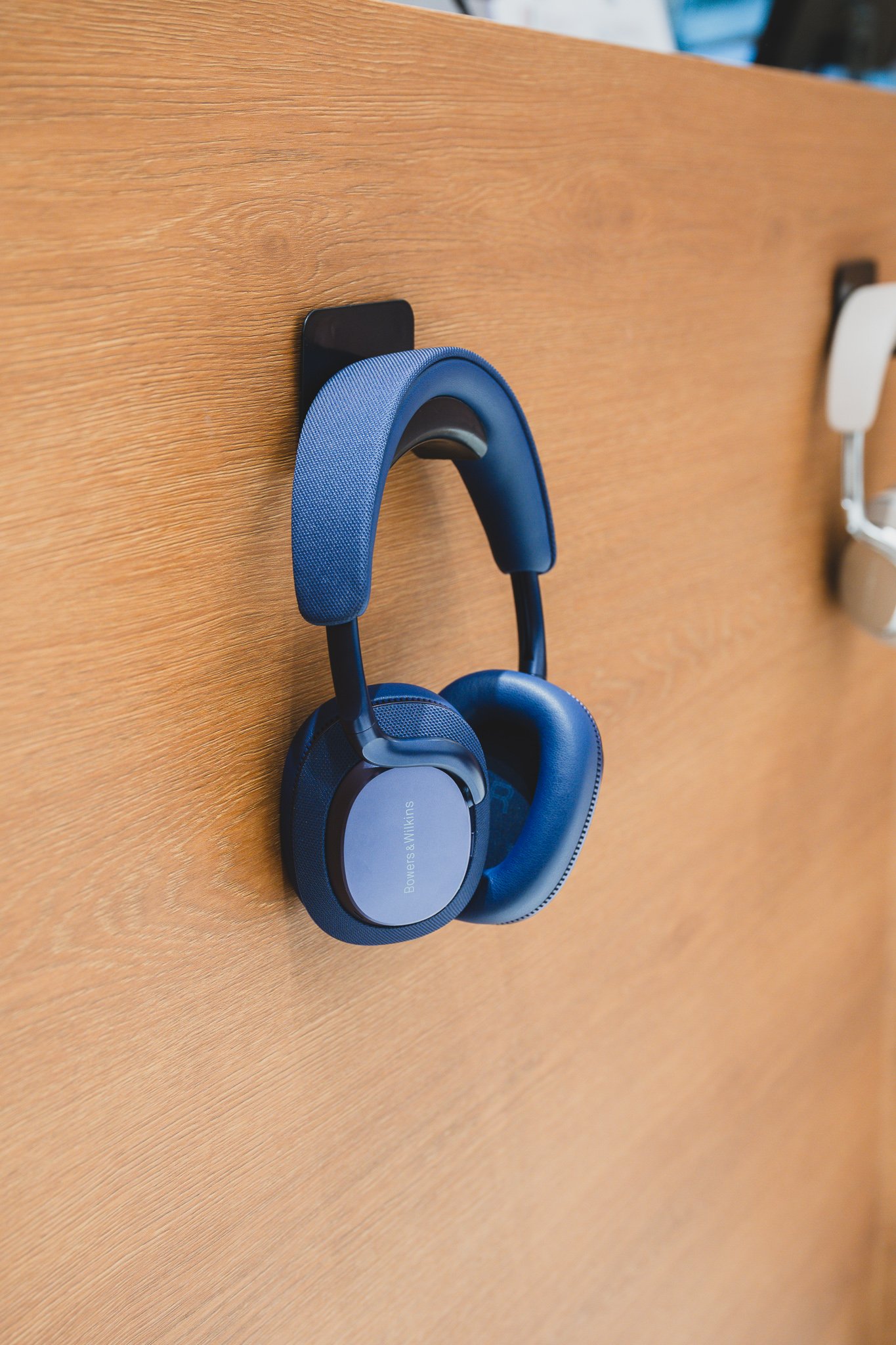 Close-up of Bowers & Wilkins headphones mounted on the wall