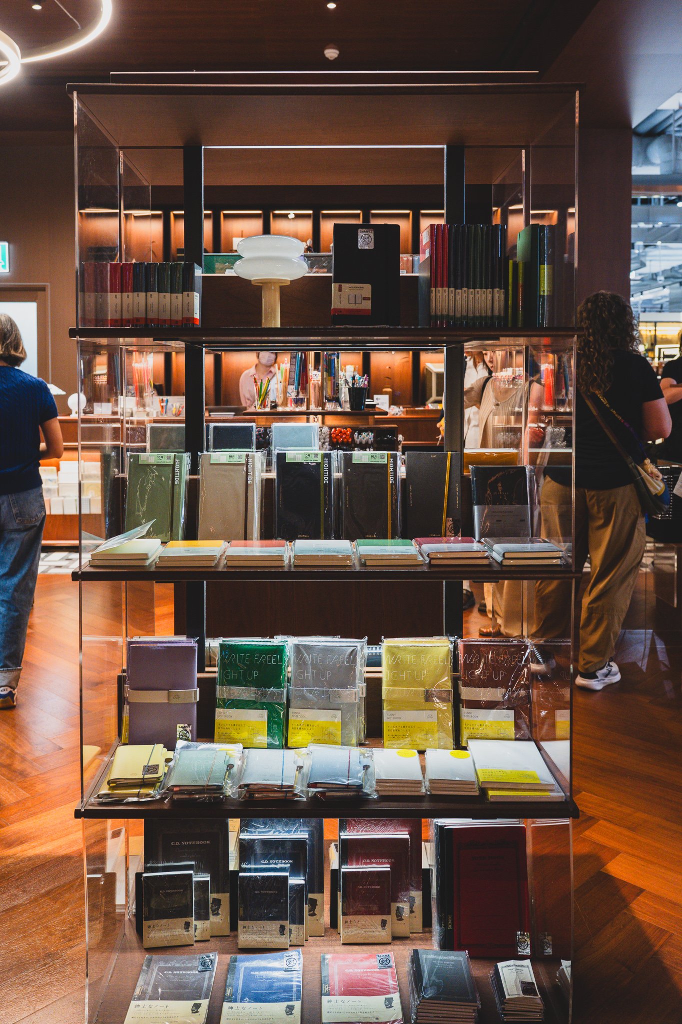 Wall of shelving packed with leather-bound diaries and color-coordinated notebook collections