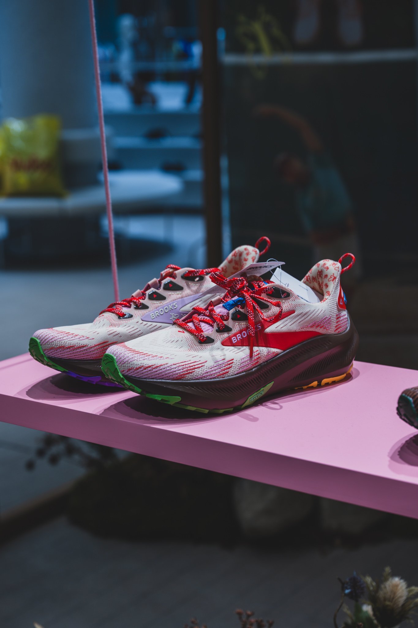 Ghost Trail shoe in ivory with red laces and a green, purple, and orange outsole