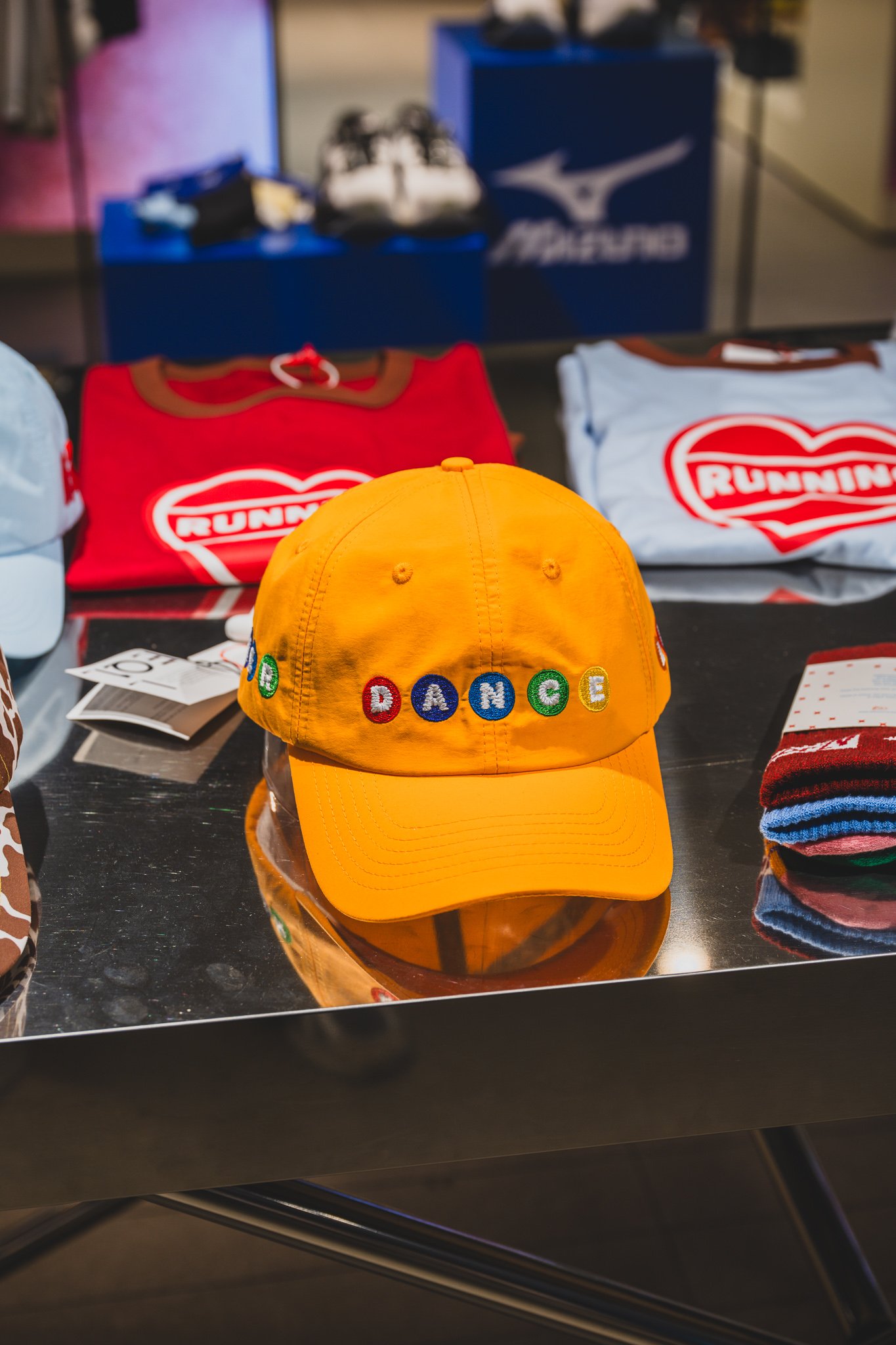 Yellow cap with "DANCE" embroidered in multicolored lettering