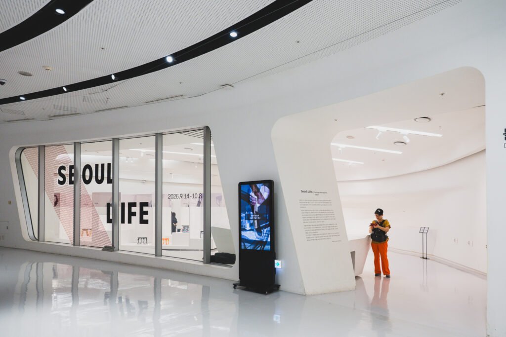 DDP interior with the SEOUL LIFE sign wall and exhibition entrance visible