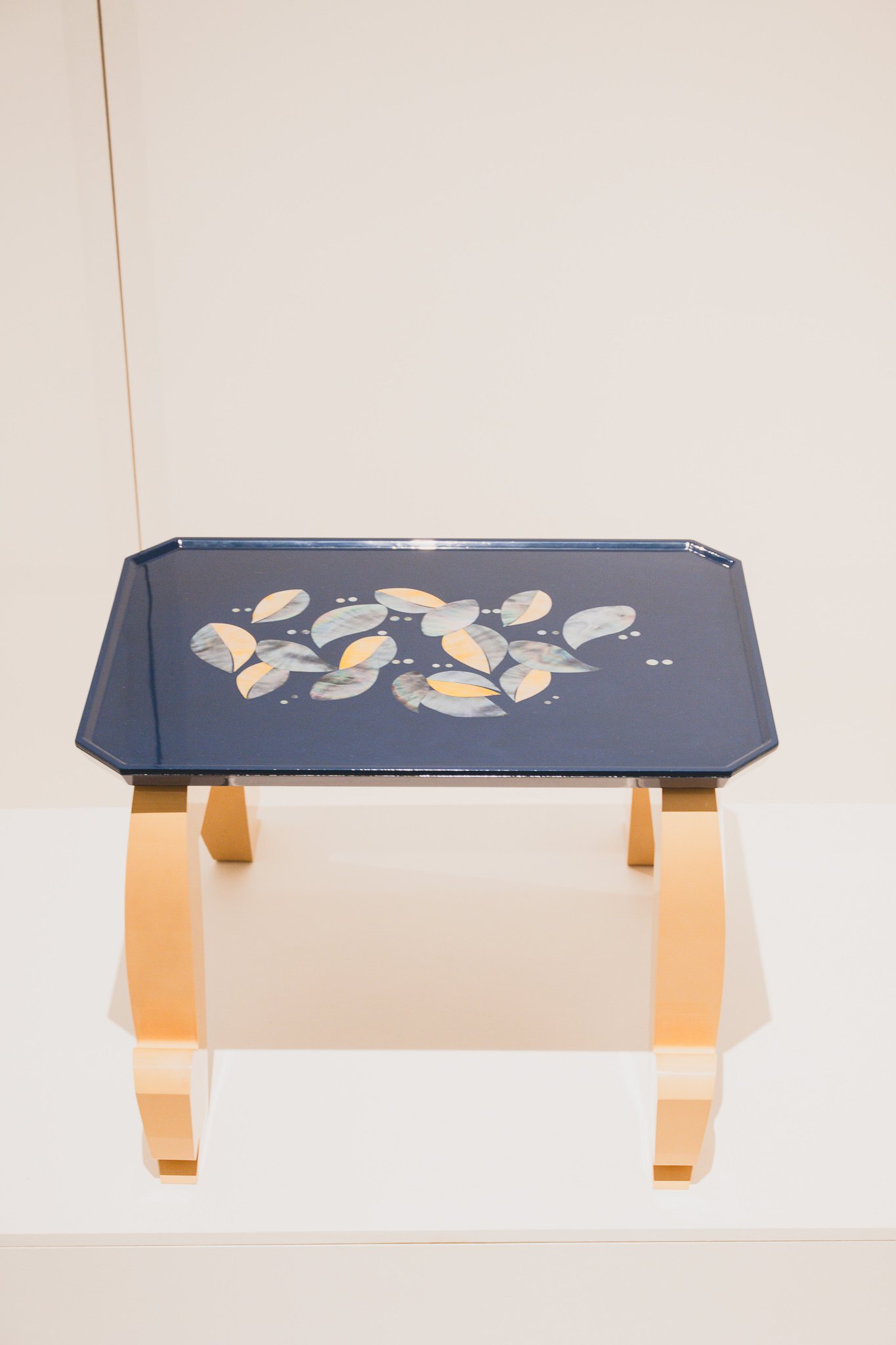 MIAWO table with navy top, gold-and-mother-of-pearl leaf pattern, and gold legs