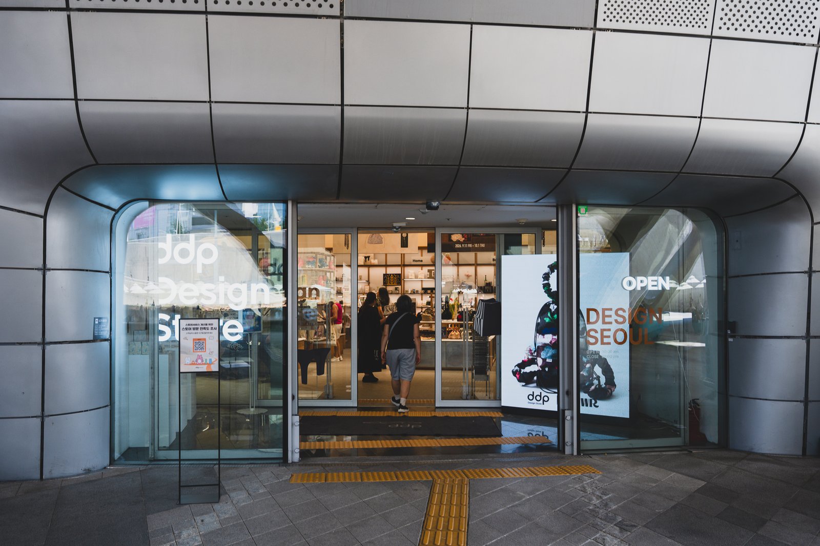 DDP Design Store entrance with glass sliding doors, seen from outside at Dongdaemun Design Plaza