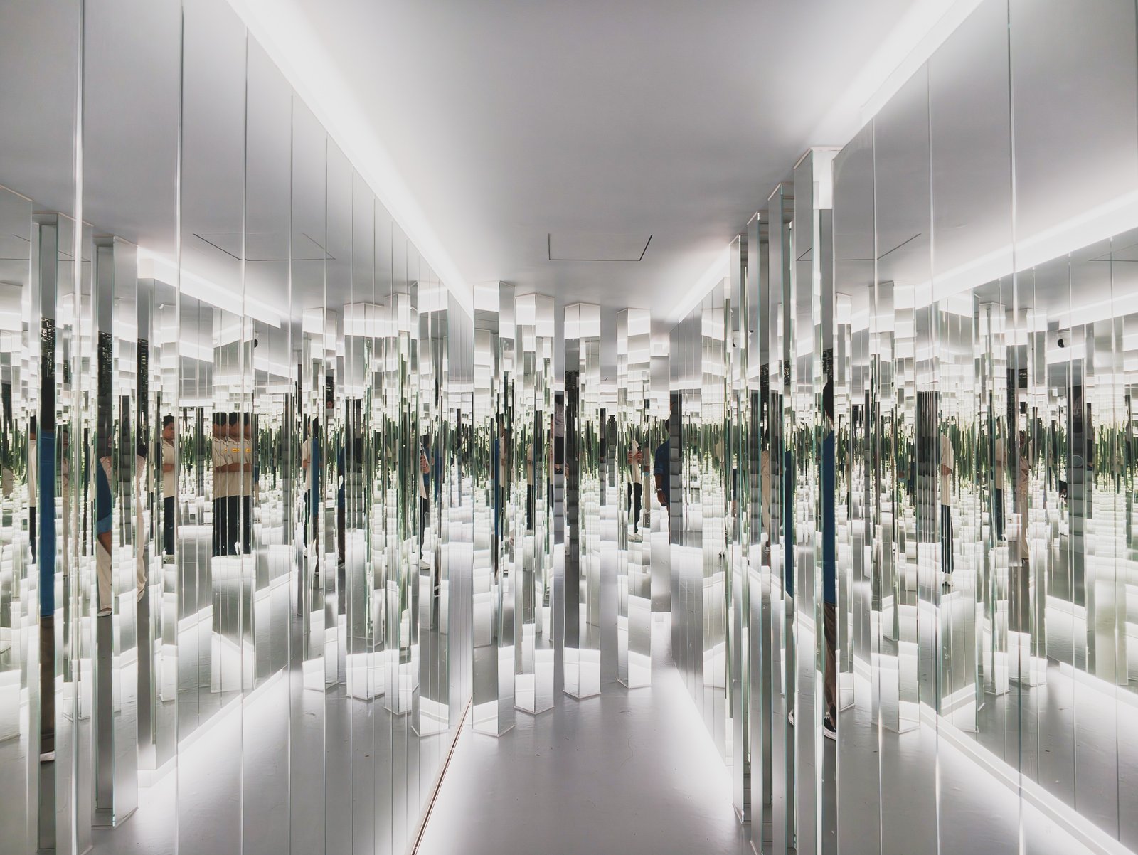Endless mirrored columns with visitors' reflections repeating in every direction