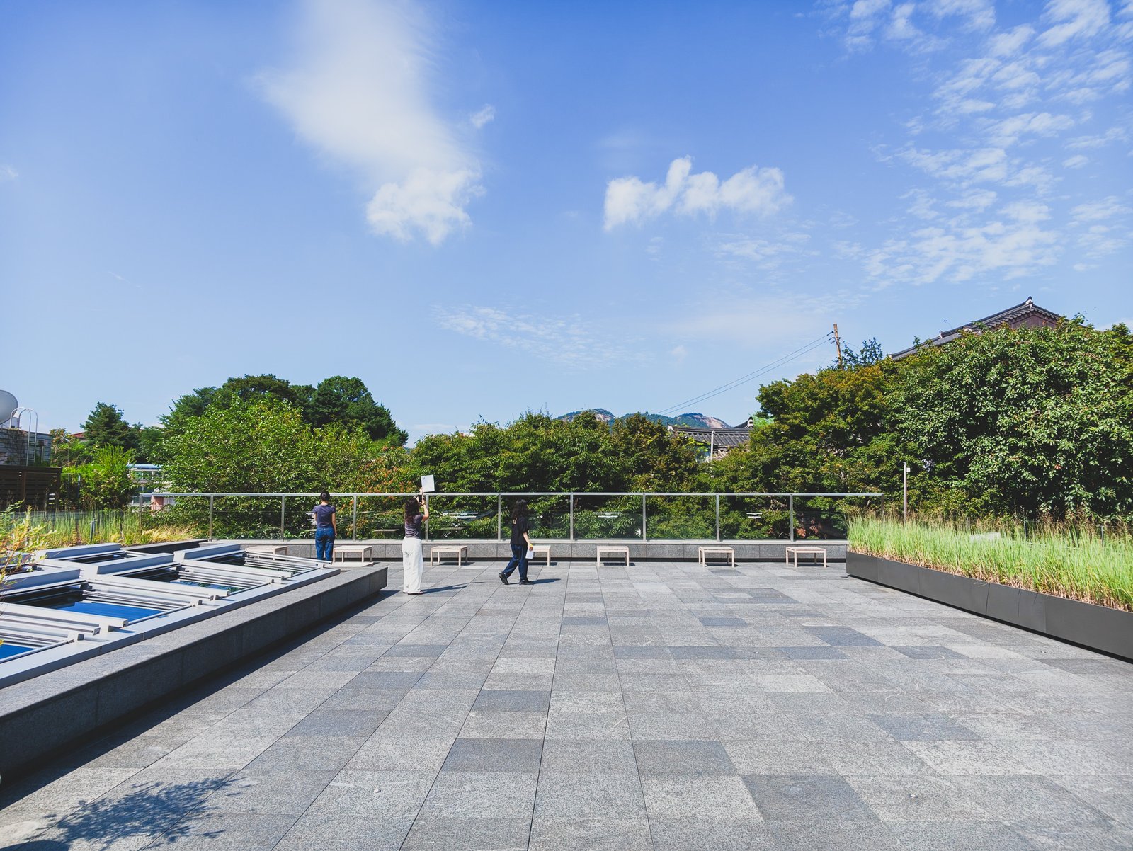 Rooftop reading room terrace with visitors seated on benches taking in the Bukchon view
