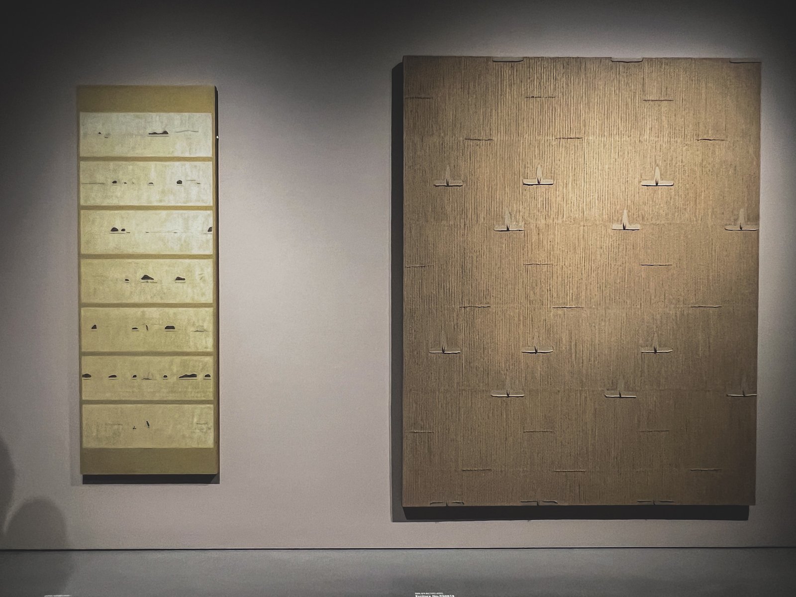 Two 1990s works hung side by side in Space Ø — Park's ridged golden hanji Ecriture on the right, one of Dodinh's spare, mark-based paintings on the left