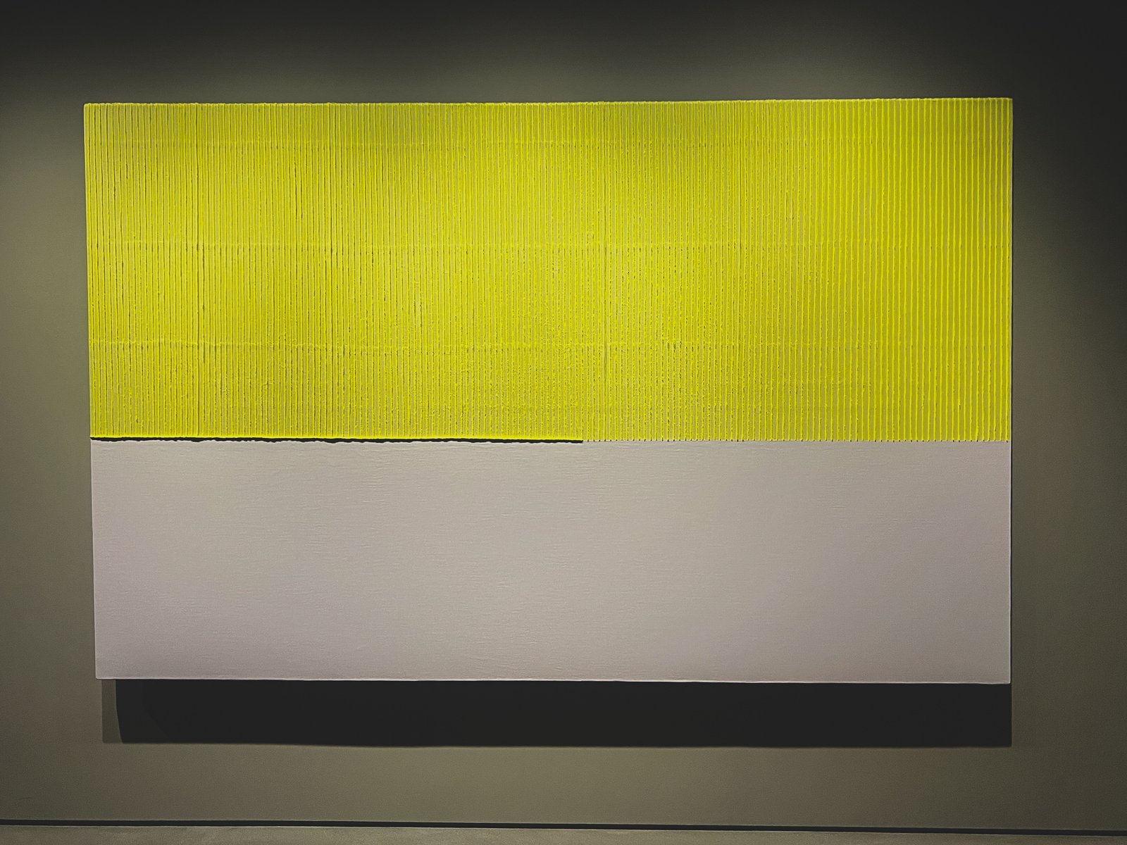 Yellow hanji Ecriture painting, dense vertical ridges above, smooth light gray below