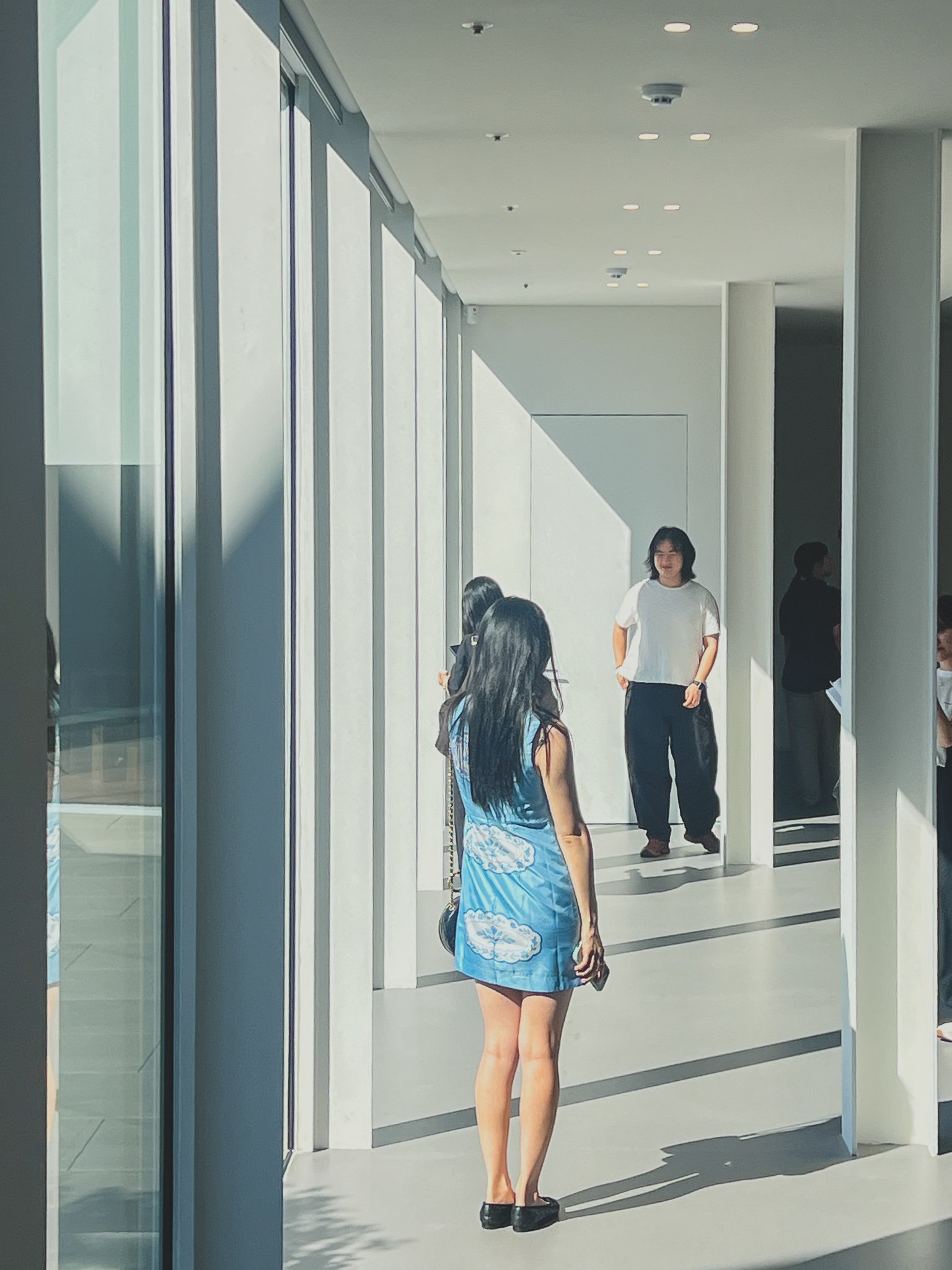 Visitors chatting in one of the museum's sunlit corridors between galleries — this kind of shot is fine, since it's outside the exhibition halls