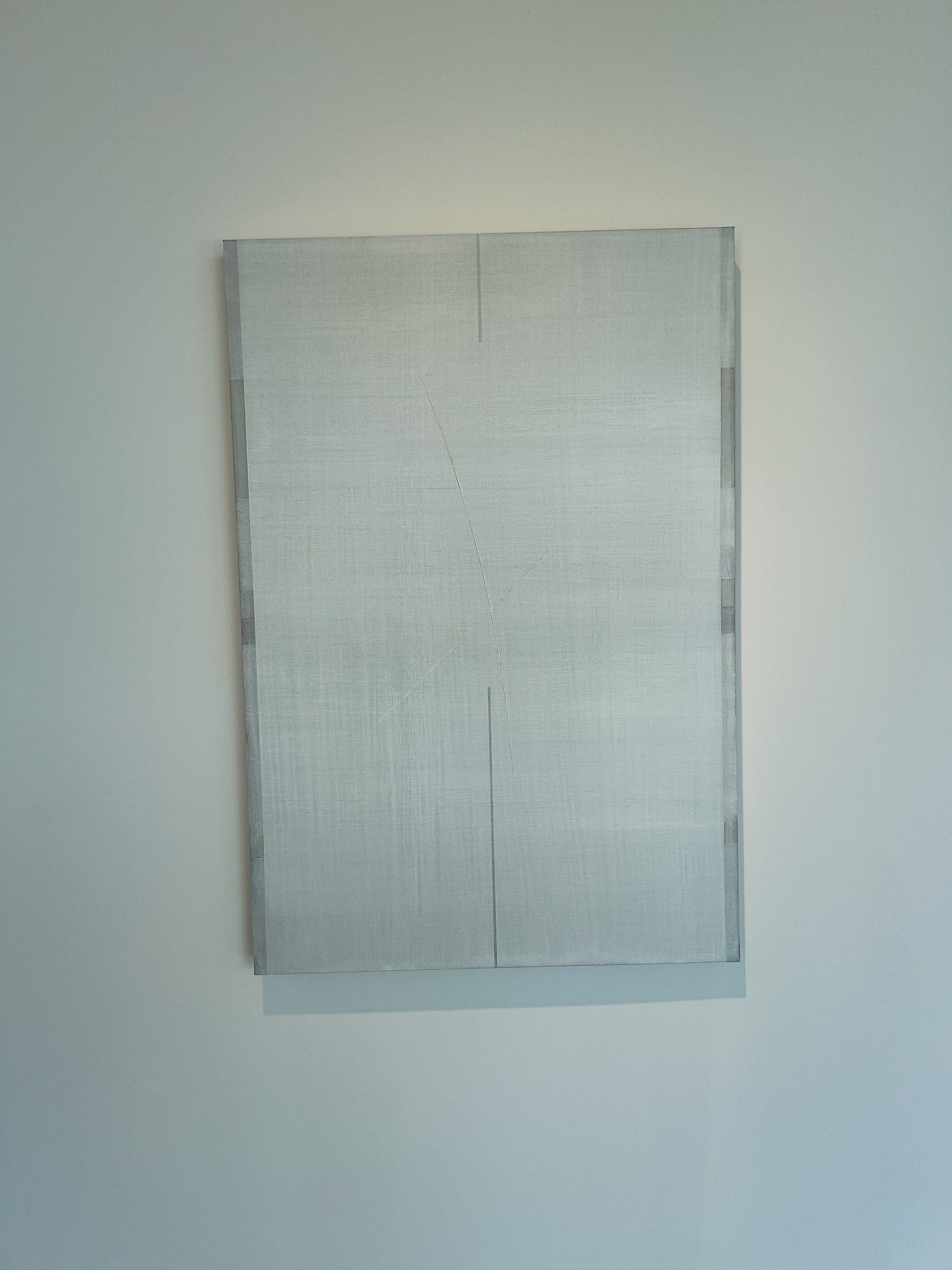 Close-up of a white hanji Ecriture work, a thin diagonal crack running through the layered brushwork