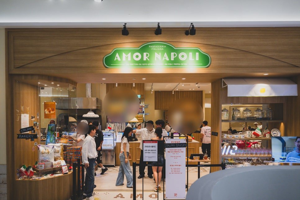 Storefront of Amor Napoli, with a green oval sign reading "AMOR NAPOLI, Pasticceria Italiana" above the entrance and customers browsing inside