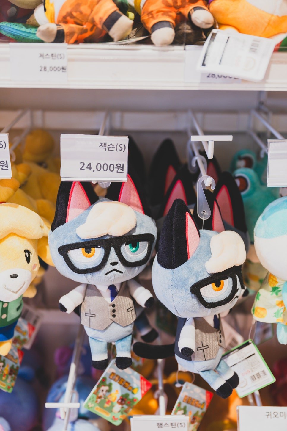 Rows of Animal Crossing character plush keyrings hanging with individual price tags, priced between ₩24,000 and ₩28,000