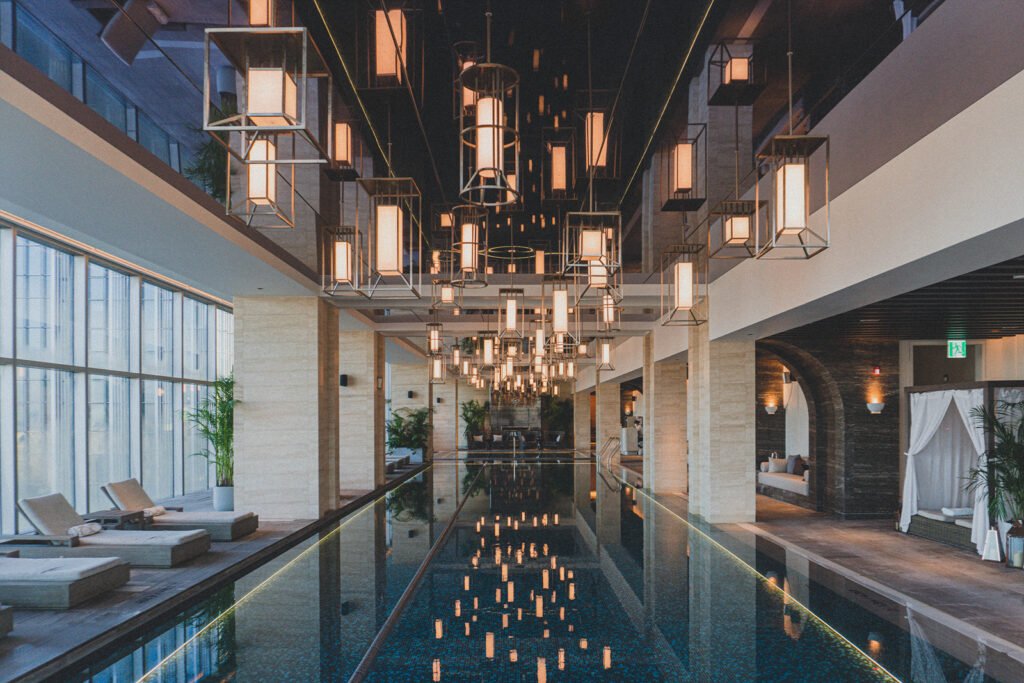 The 25m lap pool on the 26th floor of Josun Palace Gangnam, with a mirrored ceiling and hanging light installation