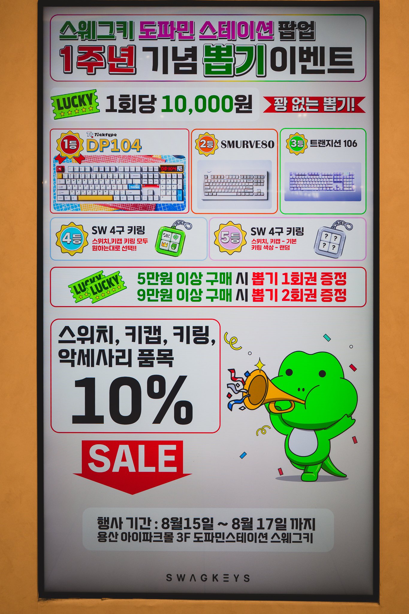 A digital signage board advertising Swagkeys' one-year anniversary "no-miss" gacha event, listing keyboard prizes for ₩10,000 per draw