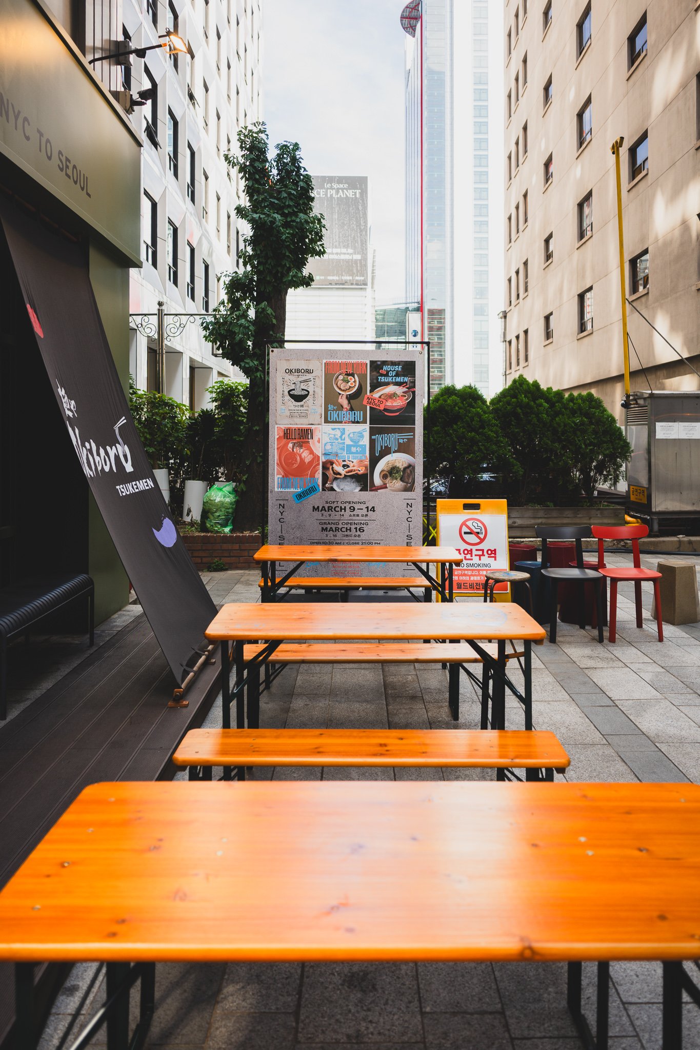 A side terrace next to the main storefront, with soft-opening and grand-opening posters still up