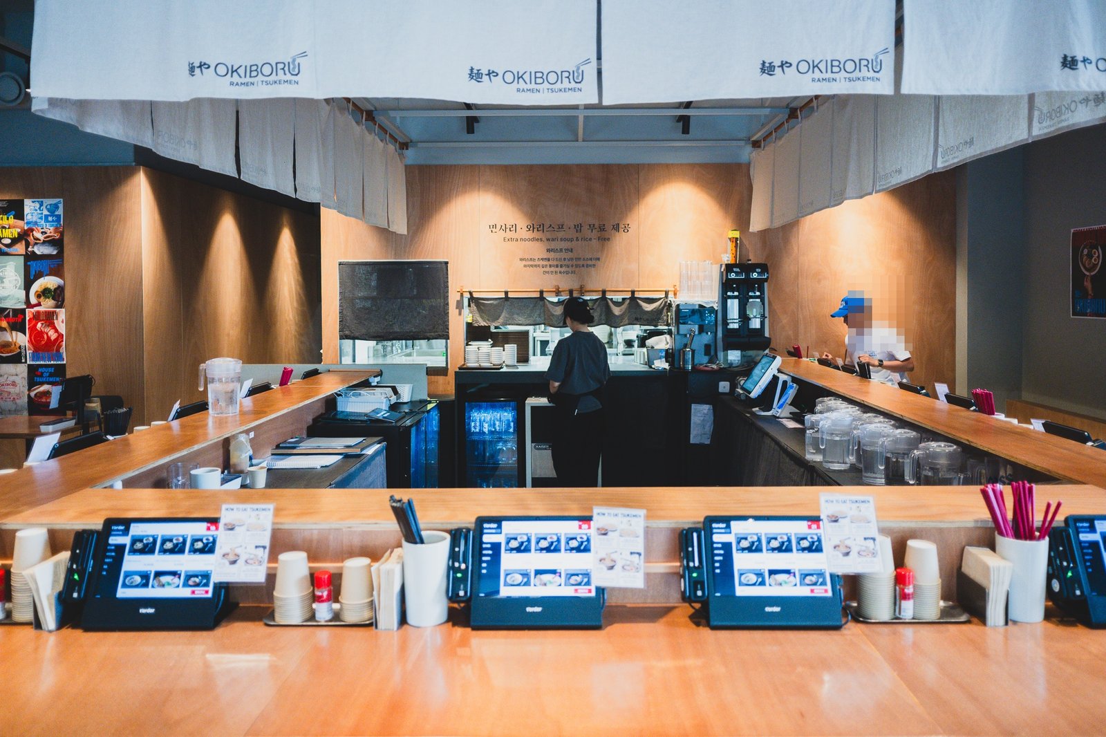 Wood-finished ordering counter with multiple self-order kiosks lined up