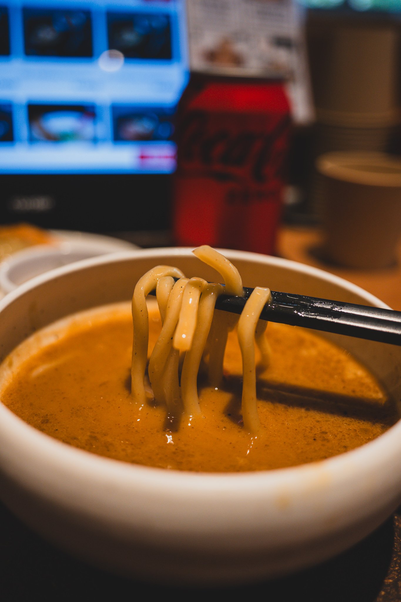 Dipping noodles into the concentrated broth bowl