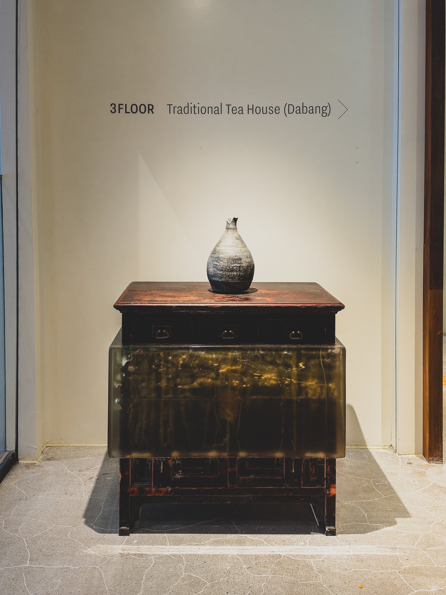 Sign reading "3 FLOOR Traditional Tea House (Dabang)" next to antique furniture