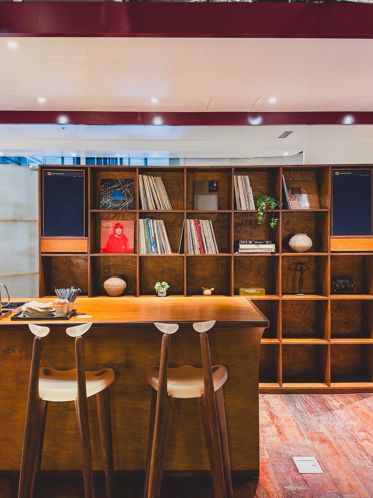 Wooden shelf stacked with vinyl records behind the bar counter